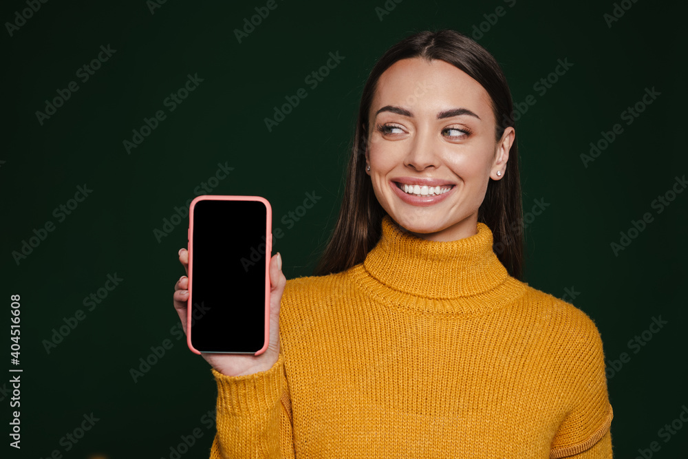 Joyful beautiful girl smiling and showing mobile phone Joyful beautiful girl smiling and showing mobile phone