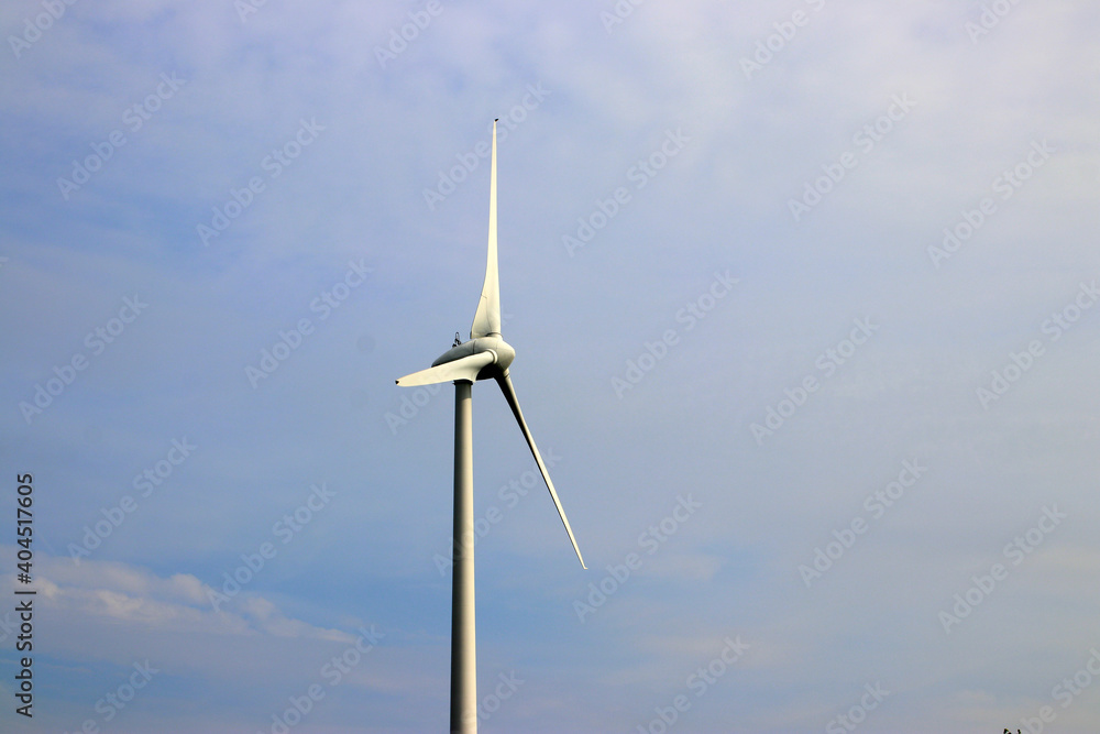 Windturbine isolated in blue sky with grey clouds Windturbine isolated in blue sky with grey clouds