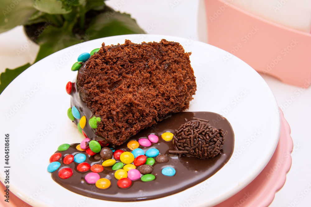 Piece of chocolate cake with brigadeiro topping and colorful chocolate pieces Piece of chocolate cake with brigadeiro topping and colorful chocolate pieces