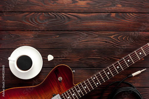 Beautiful electric guitar on with headphones and coffee desktop