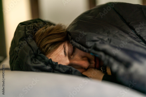 Giovane ragazza dorme nel sacco a pelo dopo una lunga camminata durante il cammino di santiago