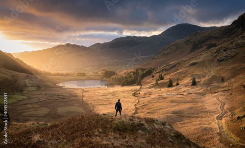 Lone figure surveying the valley as dawn breaks in the beautiful Lake District