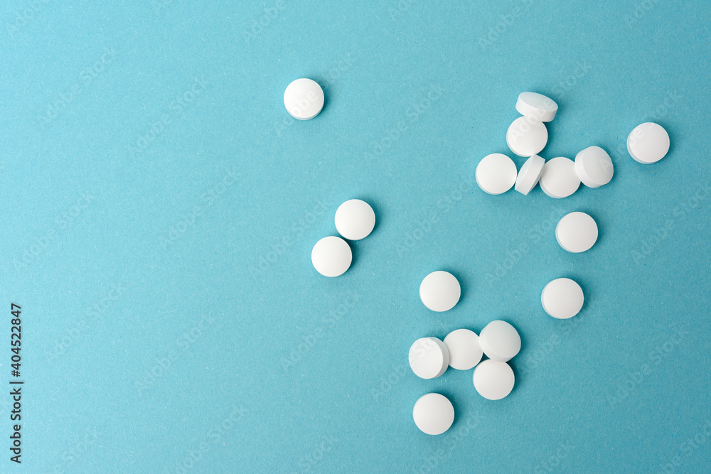 White round pill for healthcare. Medical treatment, bue background White round pill for healthcare. Medical treatment, bue background