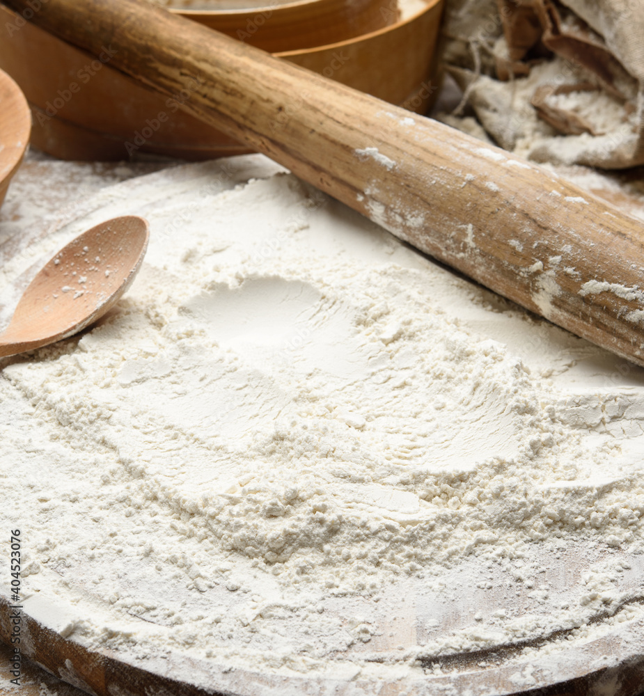 white wheat flour and wooden rolling pin on board, baking ingredients white wheat flour and wooden rolling pin on board, baking ingredients