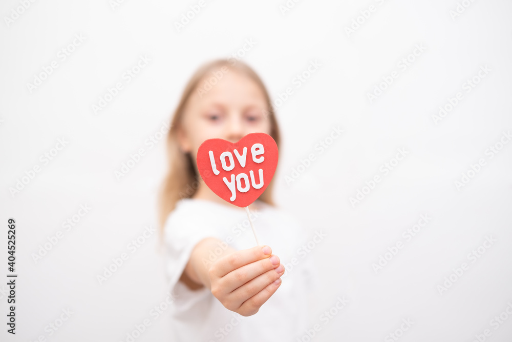 Cute girl holding a red heart with the inscription love you. card for Valentine's Day, Mother's Day, Father's Day