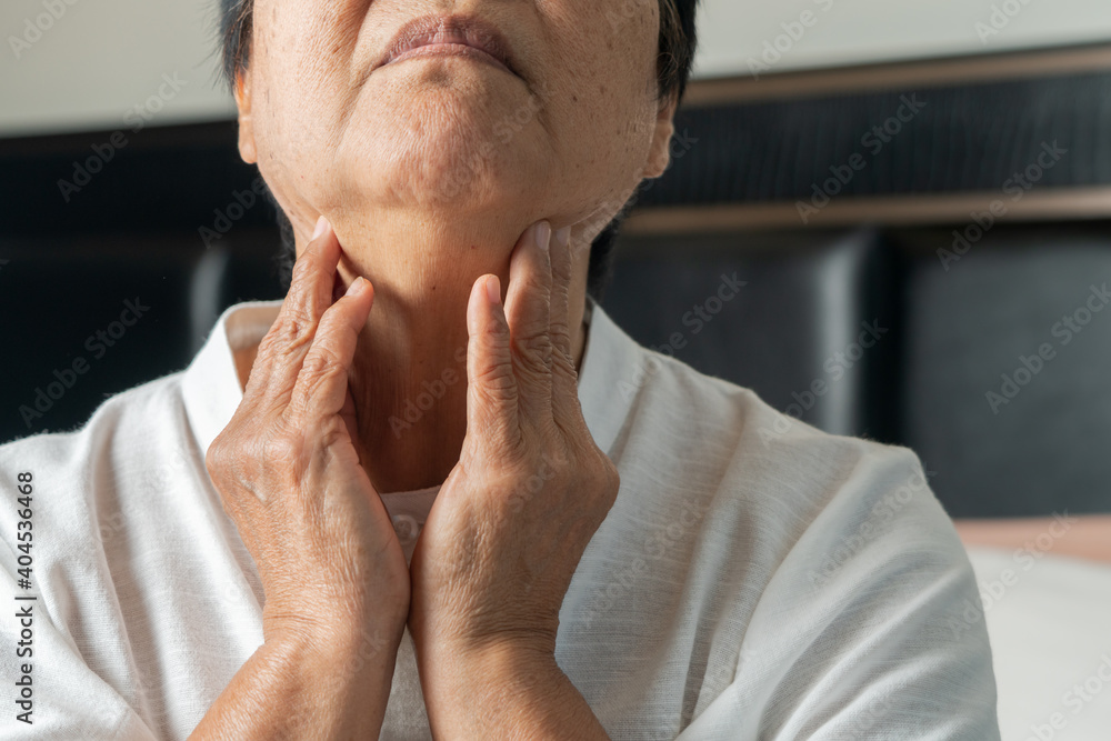 Senior adult women touching the neck feeling unwell coughing with sore throat pain.Healthcare and medicine concept Senior adult women touching the neck feeling unwell coughing with sore throat pain.Healthcare and medicine concept