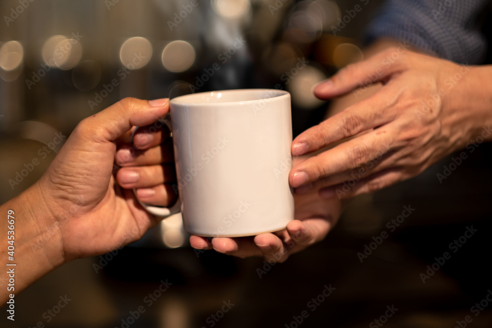 Close up of hand's barista giving coffee cup to customer's hand. Close up of hand's barista giving coffee cup to customer's hand.