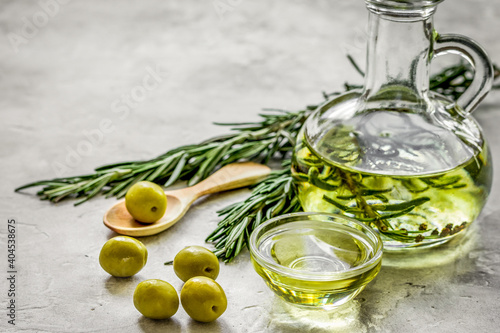 Bottle with olive oil and herbs on stone background mockup