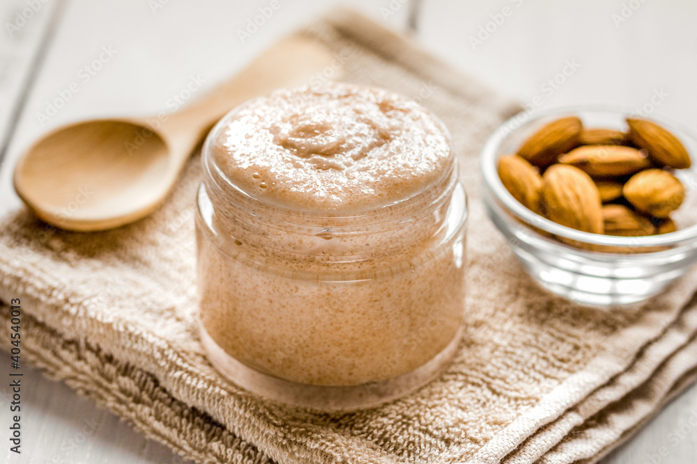 cosmetic for women with almond scrub on desk background cosmetic for women with almond scrub on desk background