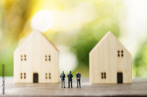 Miniature businessmen standing Investment Analysis Housing Or investment in movable property. using as background business concept and real estate concept with copy space for your text or design.