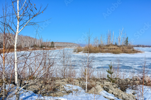  Winter landscape. An island on a frozen lake on a sunny day.