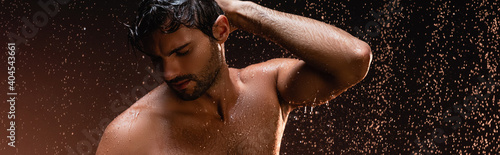 Quadro su tela sexy shirtless man posing with closed eyes under rain on dark background, banner