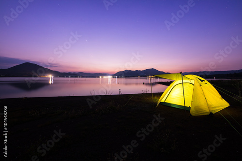 Camping tent on green grass field under cloudy sky at night time