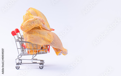 A whole chicken in a supermarket trolley on a white Supermarket, diet food, white meat chicken, free reng. Fresh raw chicken in a basket.Free rang chicken photo