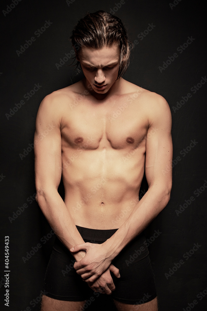 Naklejka premium Strong stripped muscle male model in white underwear on black isolated font background