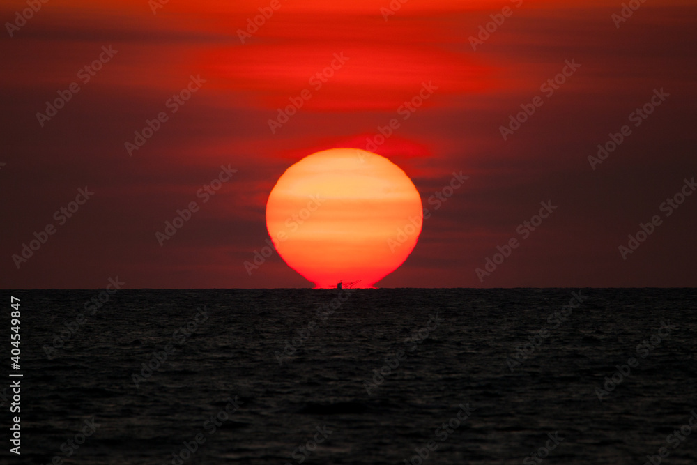 A colorful of sunset is reflecting above of sea under colorful sky A colorful of sunset is reflecting above of sea under colorful sky