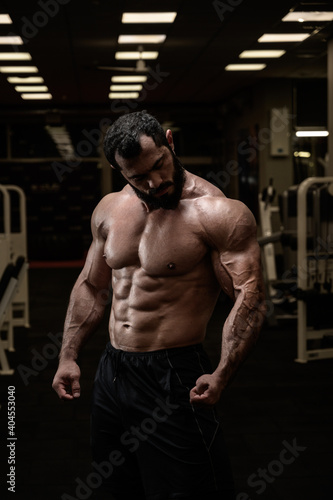 muscular bearded man in sport bodybuilding night fitness club gym