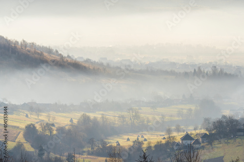 Fog rises over the village in the mountains. Carpathians, Ukraine