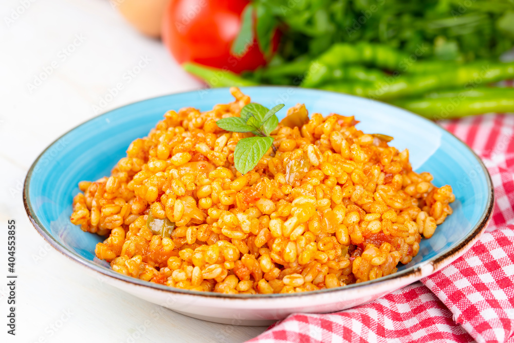 Traditional turkish bulgur pilaf with tomato sause in plate Traditional turkish bulgur pilaf with tomato sause in plate