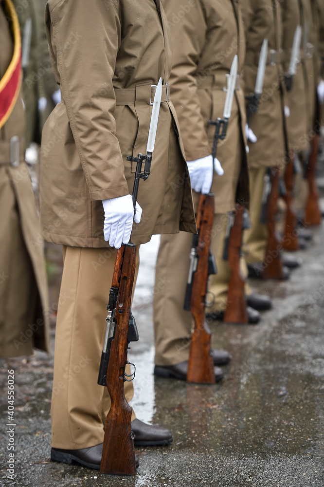 Military guard of honor holding rifles in rest position participate at a funeral in winter time Military guard of honor holding rifles in rest position participate at a funeral in winter time