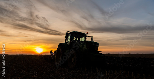 Tractor on the field during sunset.