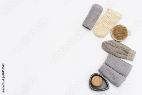 Spa still life zero waste background. Set for body care with space for text. Soap, cotton towel, washcloth for bath, wooden hairbrush.