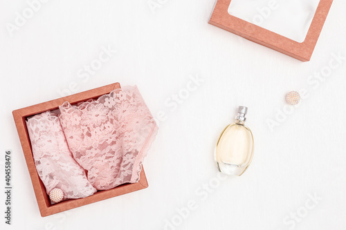 Composition with  white hearts together with pink ribbon, women lace lingerie, perfume on white background. Holiday concept for wedding, Valentines Day, romantic relation. Flat lay and top view. photo