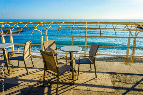 Chairs and a table by the sea in a cafe.