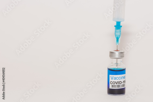 syringe and blue fluid with coronavirus vaccine and white background detail