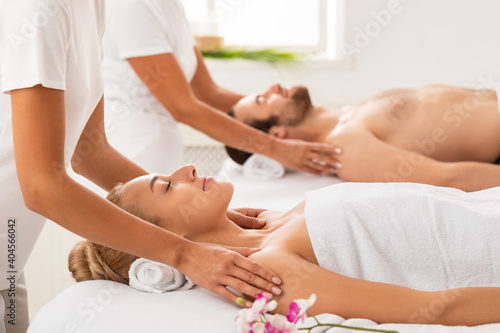 Spouses Receiving Shoulders Massage Relaxing At Luxury Spa Center