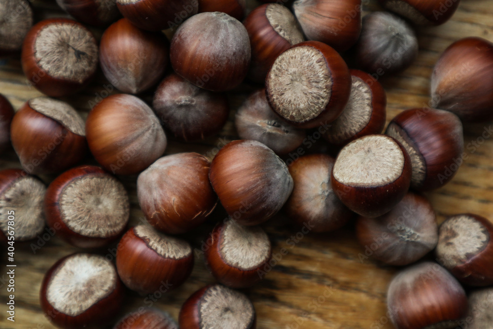 Top view Hazelnuts in nutshell, cracked nuts, wooden background.
Top view Hazelnuts in nutshell, cracked nuts, wooden background.
