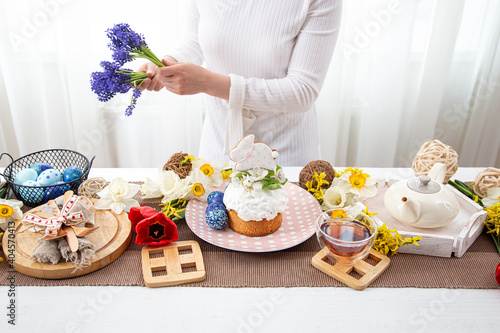 The process of decorating with flowers a festive Easter table with treats.