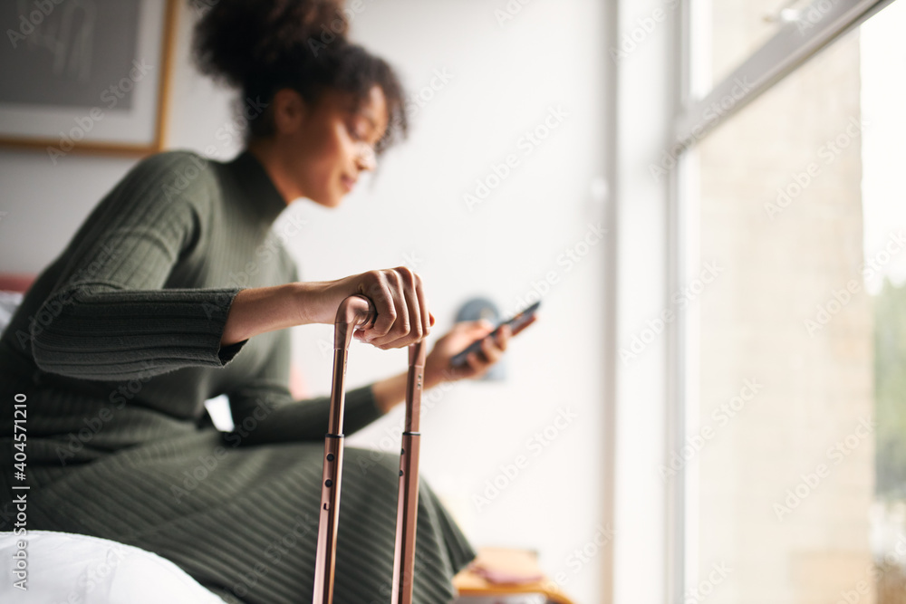 Φωτογραφία Woman with suitcase checking out of boutique hotel sitting on bed waiting for ta