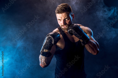 Sportsman boxer fighting on black background with shadow. Copy Space. Boxing sport concept. Smoke on background