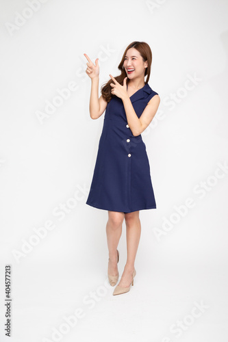 Young Asian woman smiling and pointing to empty copy space isolated on white background