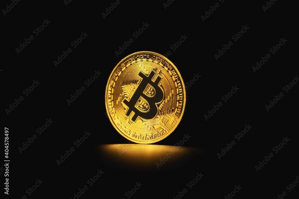 Physical shiny bitcoin agains dark background Physical shiny bitcoin agains dark background