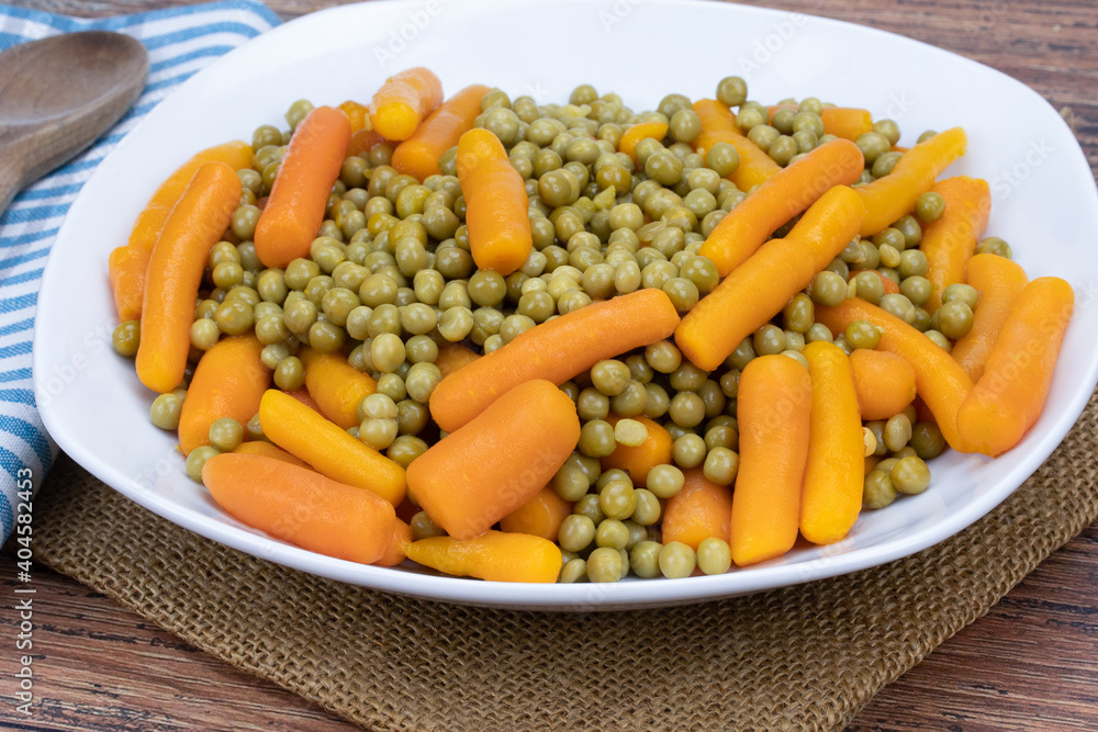 assiette de petits pois et carottes sur une table assiette de petits pois et carottes sur une table