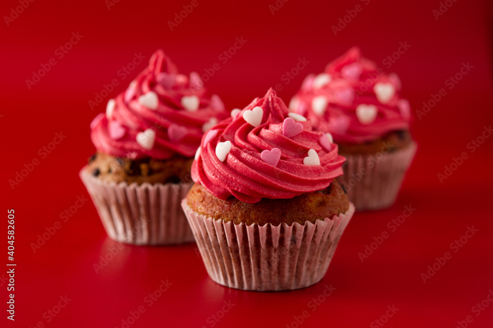 Cupcakes decorated with sugar hearts for Valentine's Day on red background Cupcakes decorated with sugar hearts for Valentine's Day on red background