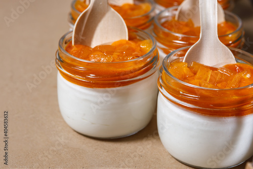Persimmon and whipped cream smoothie in a glass jar. Wooden spoons in jars.