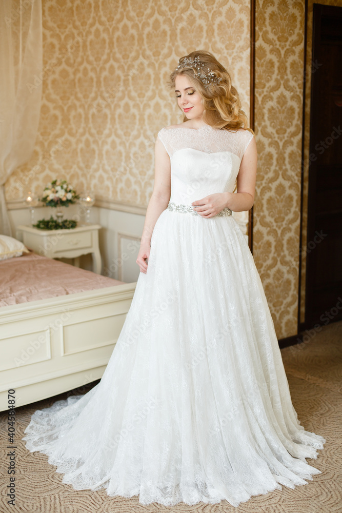 Fototapeta premium Pretty young Bride. Blonde woman with luxurious long curly hair. Boudoir morning of the bride. 
