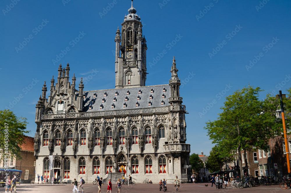 Middelburg, The Netherlands, August 2019. The town hall in a beautiful view from the market square. The facade dominates the scene, beautiful summer day, people in the square.