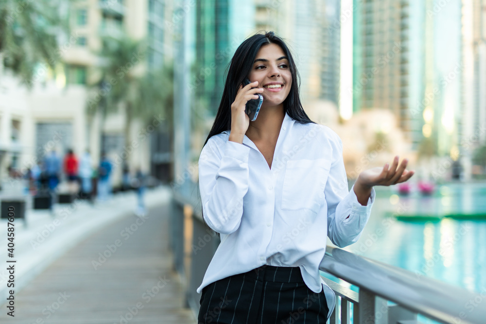 Young businesswoman using mobile phone outdor over building background Young businesswoman using mobile phone outdor over building background