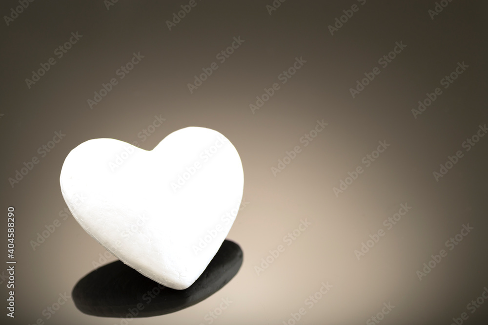 White 3d heart made of polystyrene, on a dark background with place for text. Artificial love concept, frozen heart. Studio photo. Valentine's Day. Side view White 3d heart made of polystyrene, on a dark background with place for text. Artificial love concept, frozen heart. Studio photo. Valentine's Day. Side view