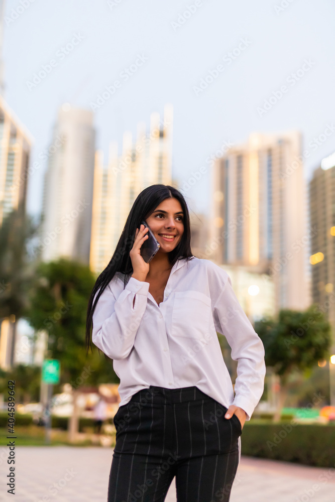 Portrait of a professional business woman smiling with mobile phone outside in the street Portrait of a professional business woman smiling with mobile phone outside in the street