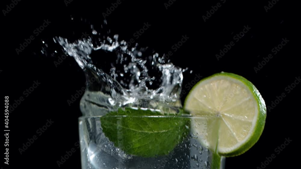 Super slow motion of falling ice cube into mojito drink, camera movement. Filmed on high speed cinema camera, 1000 fps Super slow motion of falling ice cube into mojito drink, camera movement. Filmed on high speed cinema camera, 1000 fps