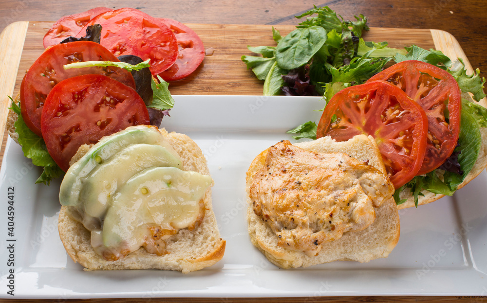 Chicken tender sandwich. Traditional classic american restaurant favorite menu item. Crispy chicken tenders served with bacon lettuce tomato onion and guacamole on a toasted bun.