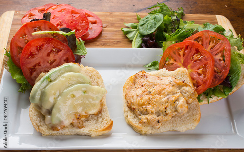 Chicken tender sandwich. Traditional classic american restaurant favorite menu item. Crispy chicken tenders served with bacon lettuce tomato onion and guacamole on a toasted bun.