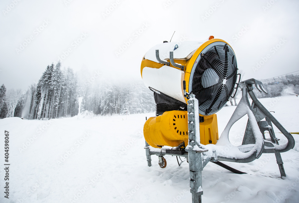 Snow cannon, machine or gun snowing the slopes or mountain for skiers ans  snowboarders, artificial snow Stock Photo