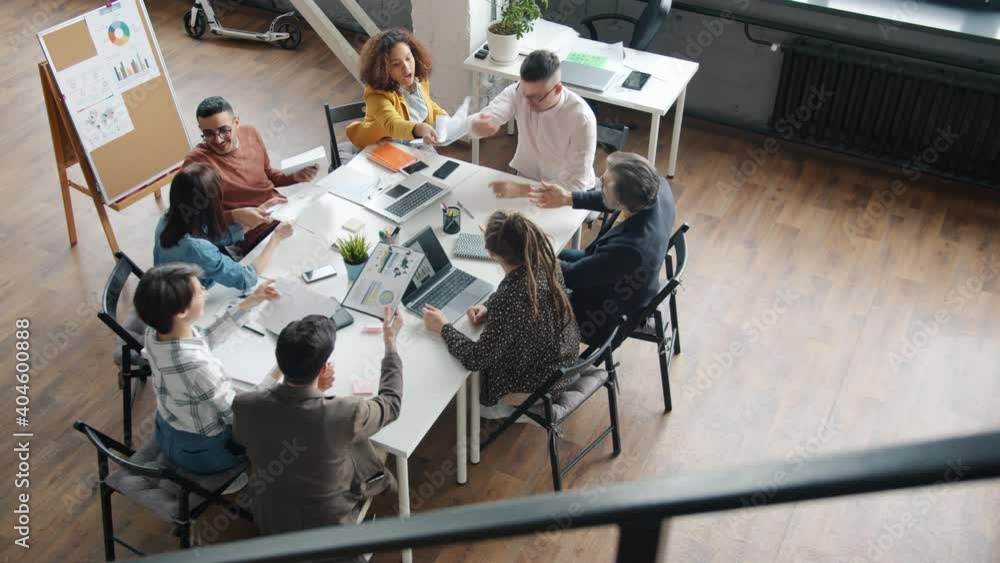 Business teammates cheerful men and women are talking and exchanging documents working at project in office. Creative people and workplace concept. Business teammates cheerful men and women are talking and exchanging documents working at project in office. Creative people and workplace concept.