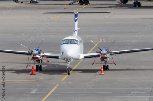 Small private jet turboprop parked, front view.